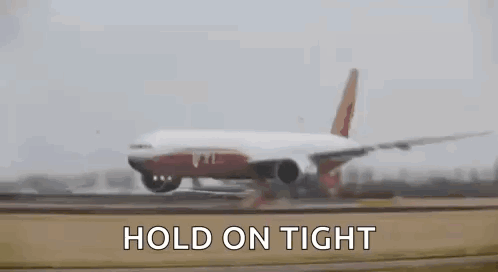 A Large Passenger Jet Is Taking Off From An Airport Runway With The Words `` Hold On Tight '' Written Above It . GIF