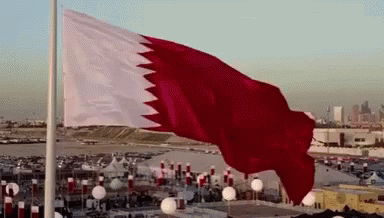 A Large Red And White Flag Flies In The Wind GIF