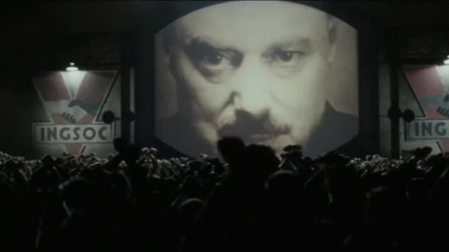 Large Screen Showing Man's Face With Signs GIF