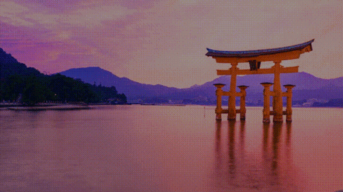 A Large Torii Gate Is In The Middle Of A Body Of Water GIF