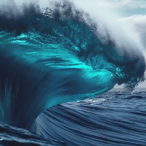 Large Wave Breaking In Ocean Resembling Shark GIF