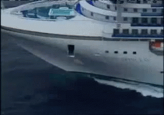A Large White Cruise Ship Is Floating On The Ocean GIF