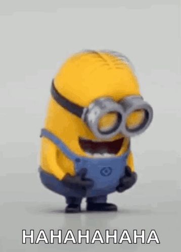 A Laughing Minion With Goggles On His Eyes Is Standing On A Table . GIF