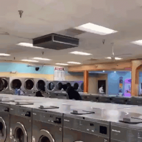 A Laundromat With Lots Of Washers And Dryers And A Sign That Says No Pets GIF