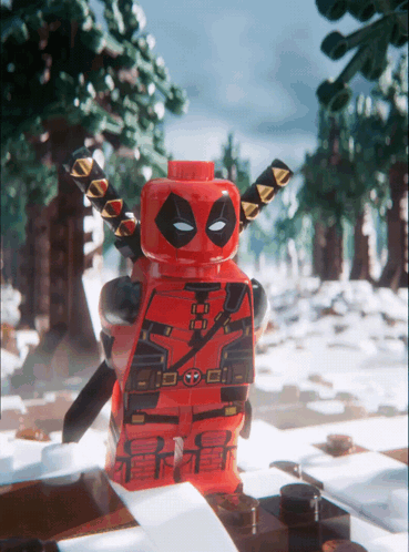 A Lego Deadpool Figure Stands In The Snow GIF