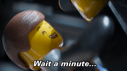 A Lego Figure Says " Wait A Minute " In A Dark Room GIF