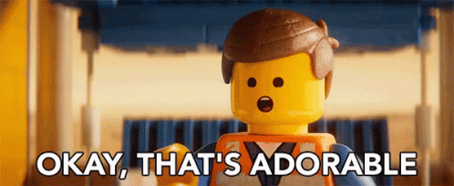 A Lego Man Says Okay That 'S Adorable In Front Of A Building GIF