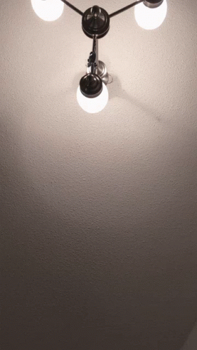 A Light Hanging From The Ceiling With Three Lights On It GIF