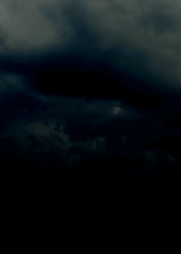 A Lightning Bolt Is Visible In The Dark Sky GIF
