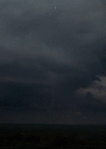 A Lightning Bolt Strikes The Ground In The Middle Of The Field GIF
