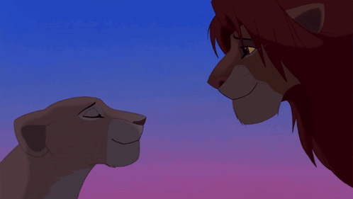 A Lion And A Lioness Looking At Each Other With A Blue Sky In The Background GIF