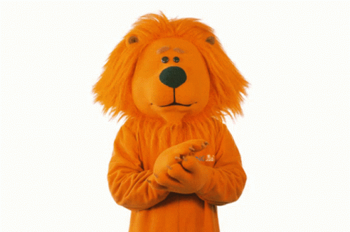 a lion mascot is wearing an orange sweater with the word abc on the sleeve