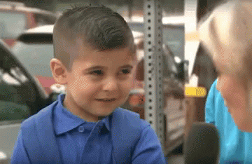 A Little Boy In A Blue Shirt Is Talking To A Woman GIF