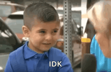 A Little Boy In A Blue Shirt Is Talking To A Woman . GIF