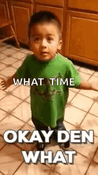A Little Boy In A Green Shirt Is Standing On A Tiled Floor And Making A Funny Face . GIF