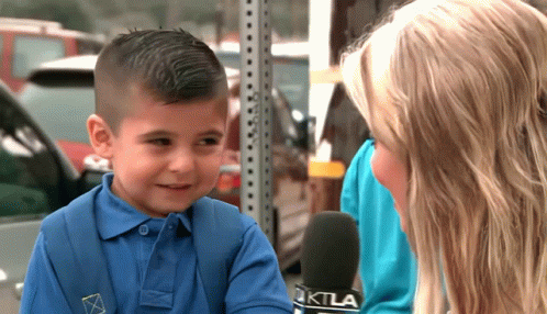 A Little Boy Is Being Interviewed By A Woman With A Microphone That Says Ktla On It GIF