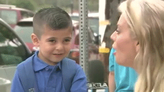 A Little Boy Is Being Interviewed By A Woman With A Microphone That Says Ktla On It GIF