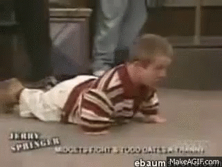 A Little Boy Is Crawling On The Floor With His Legs Crossed . GIF