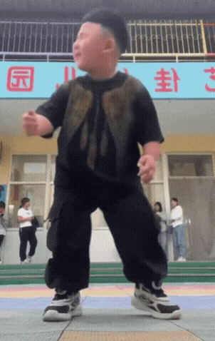 a little boy is dancing in front of a sign that says ' s ' on it