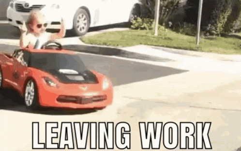 A Little Boy Is Driving A Red Toy Car On A Street . GIF