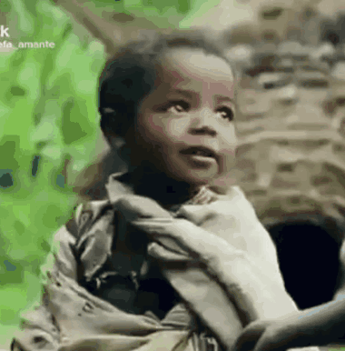 a little boy is holding a person 's hand .