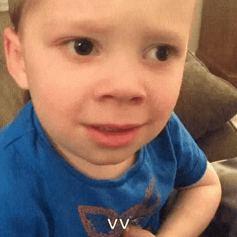 A Little Boy Is Making A Funny Face While Sitting On A Couch . GIF