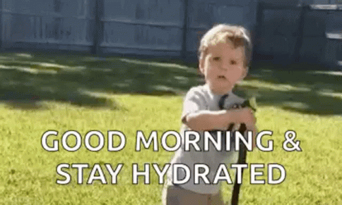 A Little Boy Is Riding A Scooter In The Grass And Saying `` Good Morning & Stay Hydrated '' . GIF