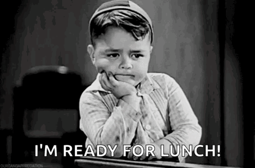 A Little Boy Is Sitting At A Desk With His Hand On His Chin And Saying `` I 'M Ready For Lunch ! '' GIF