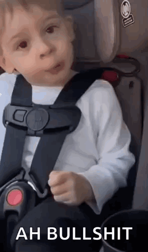 A Little Boy Is Sitting In A Car Seat And Making A Face . GIF
