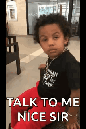 A Little Boy Is Sitting In A Chair With The Words `` Talk To Me Nice Sir '' Written On His Face . GIF