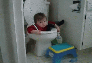 A Little Boy Is Sitting On A Toilet Next To A Toy Stool GIF