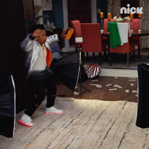 A Little Boy Is Standing In A Room With A Nick Logo On The Wall GIF
