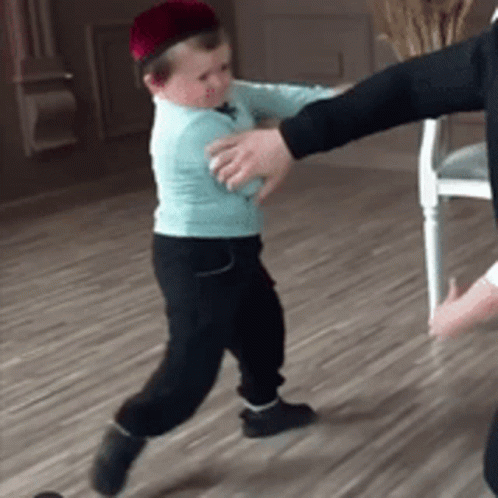 A Little Boy Wearing A Hat Is Being Held By A Man GIF