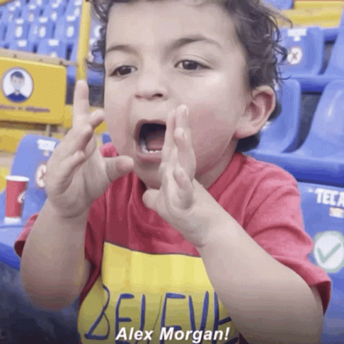 A Little Boy Wearing A Red Shirt That Says Alex Morgan GIF