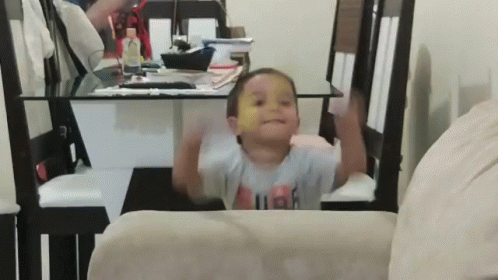 A Little Boy Wearing A Shirt That Says High Is Sitting On A Chair GIF