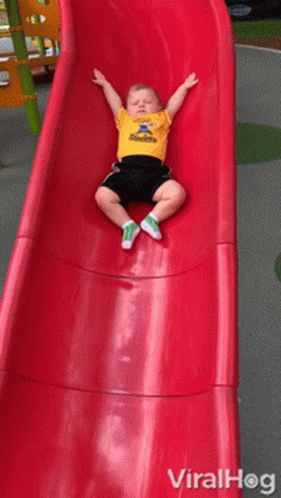 A Little Boy Wearing A Steelers Shirt Is Sitting On A Slide GIF
