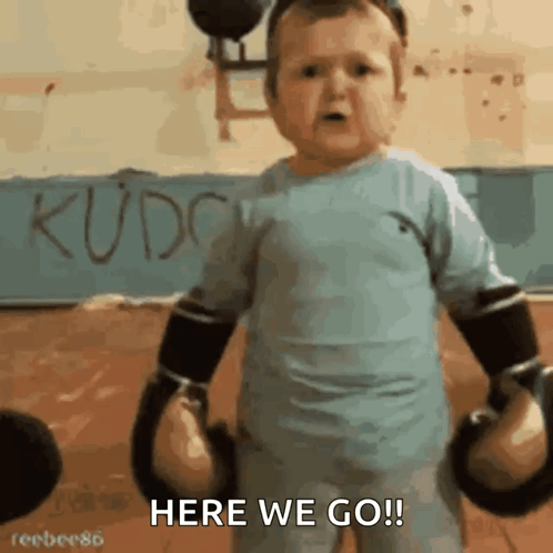 A Little Boy Wearing Boxing Gloves Says Here We Go GIF