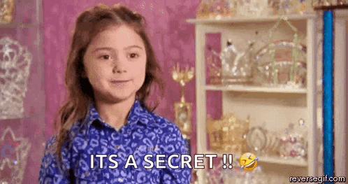 a little girl in a blue shirt is saying `` it 's a secret '' .