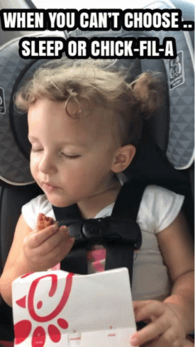 A Little Girl In A Car Seat Eating A Piece Of Chicken GIF