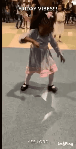 A Little Girl In A Dress Is Dancing On A Floor In A Room . GIF