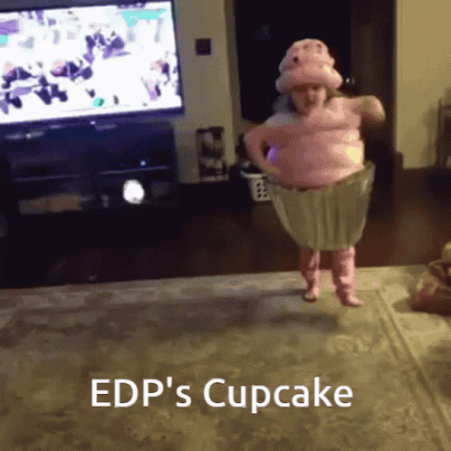 A Little Girl In A Pink Cupcake Costume Is Jumping In The Air GIF