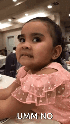 A Little Girl In A Pink Dress Is Making A Funny Face And Says Umm No GIF