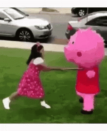 A Little Girl In A Pink Dress Is Playing With A Pink Pig Mascot . GIF