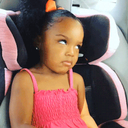 A Little Girl In A Pink Dress Sits In A Pink Car Seat GIF