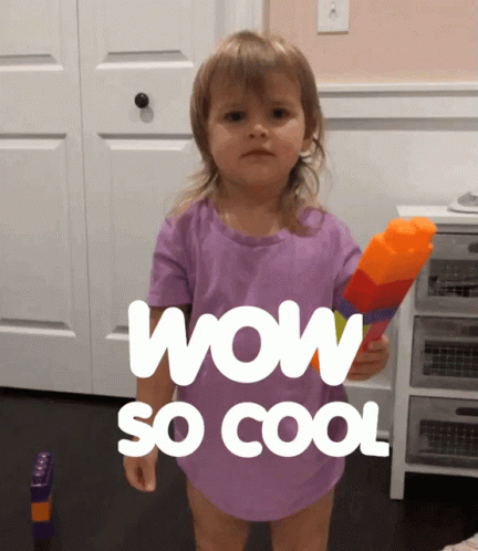 A Little Girl In A Purple Shirt Is Holding A Water Gun And Says Wow So Cool GIF
