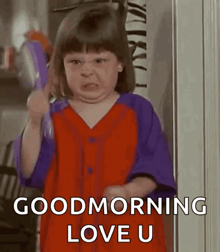 A Little Girl In A Red And Purple Dress Is Holding A Tambourine And Making A Funny Face . GIF