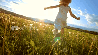 A Little Girl In A White Dress Is Running Through A Field Of Tall Grass GIF