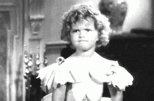 A Little Girl In A White Dress Is Standing In Front Of A Man . GIF