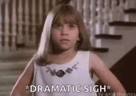 A Little Girl In A White Dress Is Standing In Front Of A Set Of Stairs And Says `` Dramatic Sigh '' . GIF