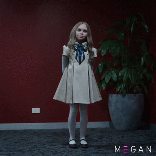 A Little Girl In A White Dress Stands In Front Of A Potted Plant With Megan Written On The Bottom Right GIF